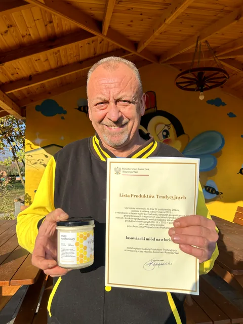Sylwester prezentuje certyfikat tradycyjnego lasowiackiego miodu nawłociowego